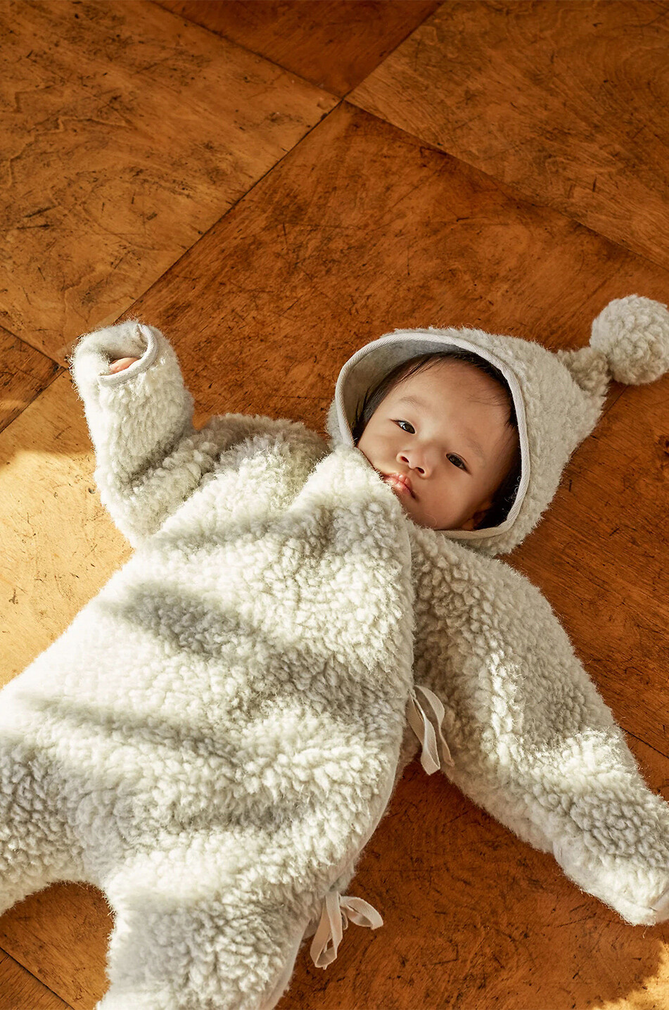 Pilote bébé en laine mérinos à capuche Milk Snugglesuit